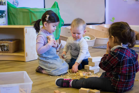 nursery students sitting on the floor playing